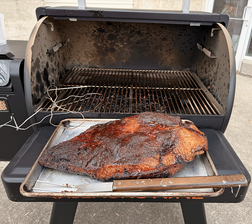 Image of brisket in front of pellet grill as it finished cooking